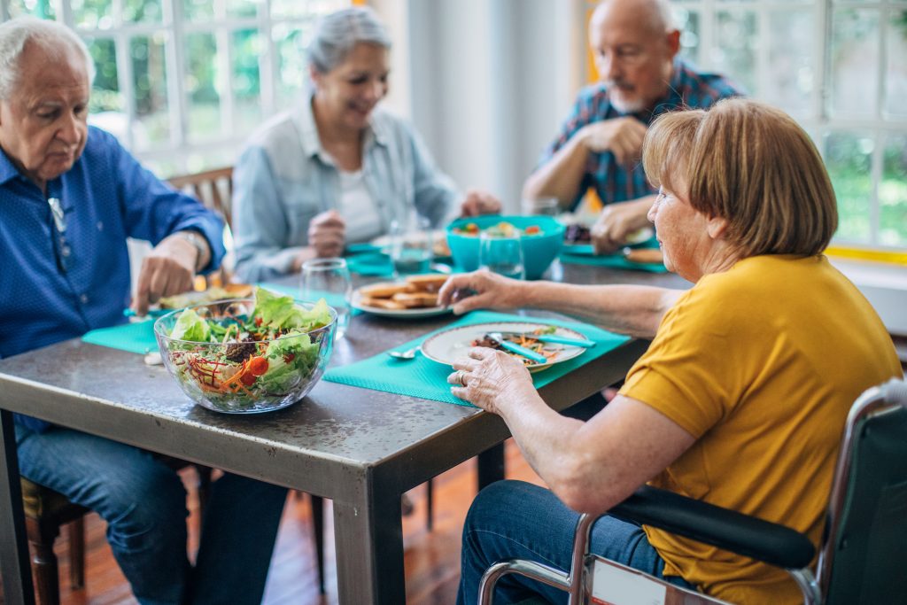 Group of seniors having meal in their retirement home