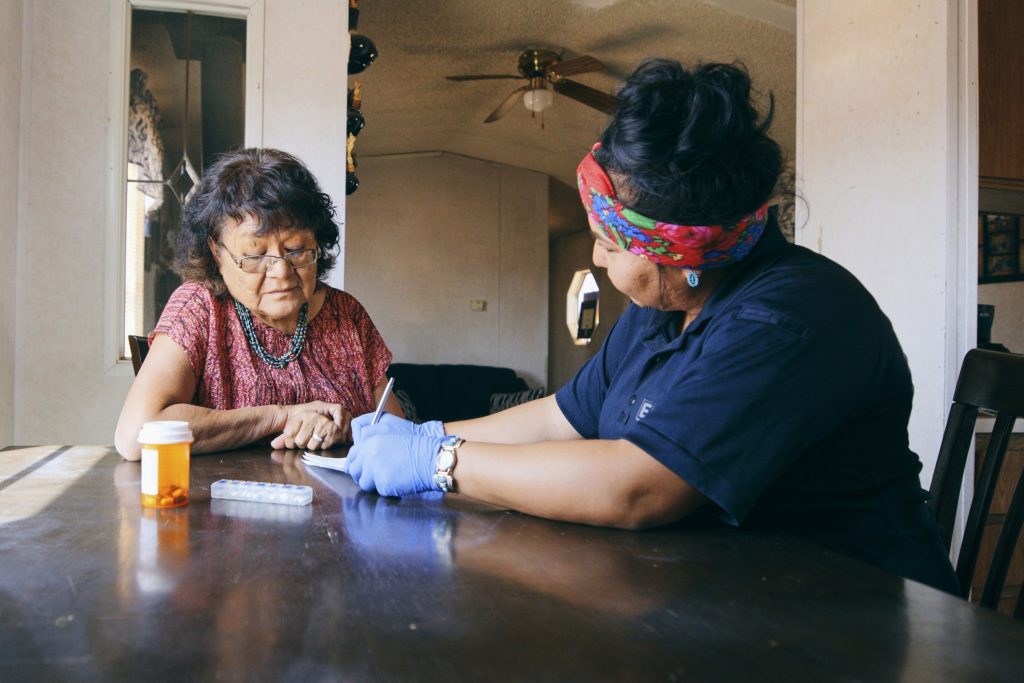 Healthcare worker talking to elderly woman