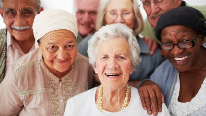 A group of seniors smiling together while in a retirement home