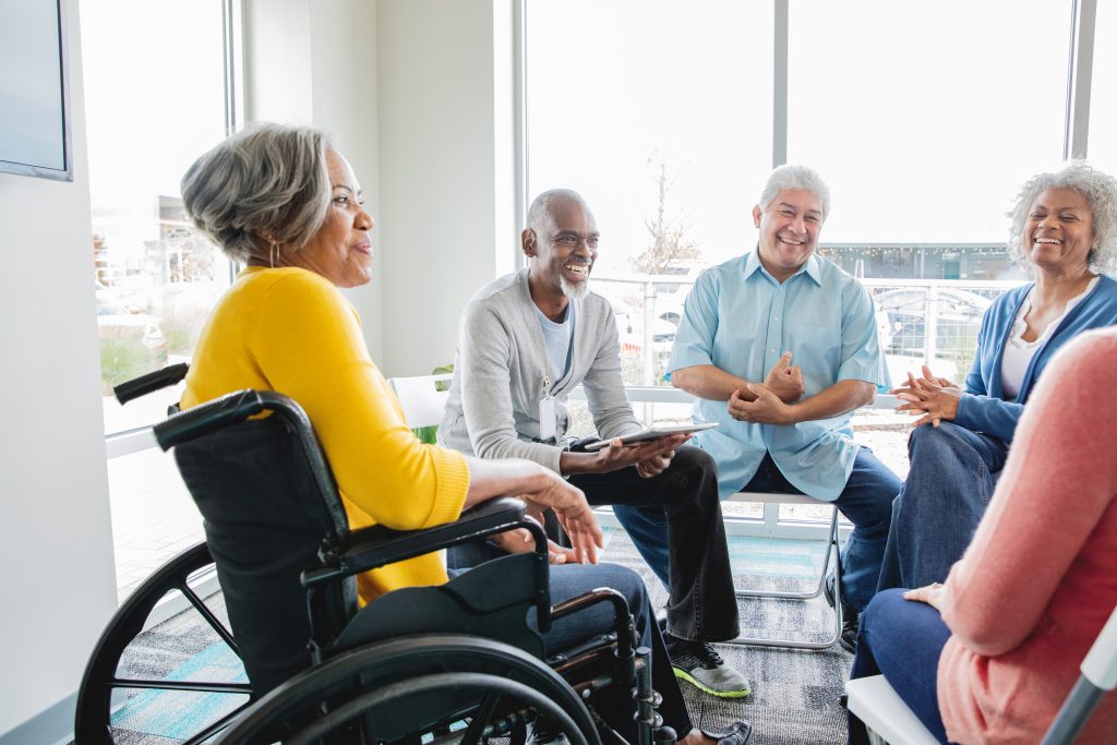 Senior woman in wheelchair attending support group with other seniors