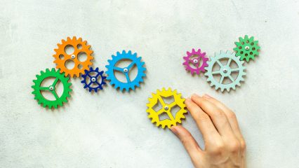 Hand holding a chain of gears cogwheels. Business process and automation concept