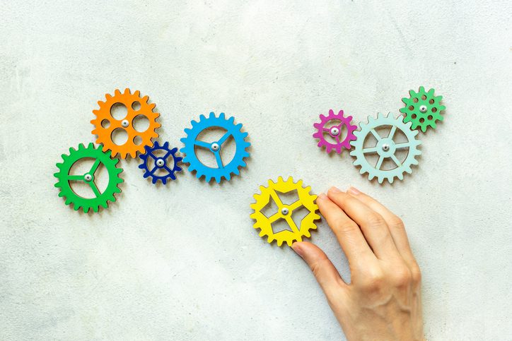 Hand holding a chain of gears cogwheels. Business process and automation concept